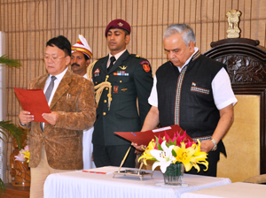 The Governor of Arunachal Pradesh Lt. Gen (Retd) Nirbhay Sharma administrating the oath to the Pro-tem Speaker Shri Kameng Dolo, a senior member of the Sixth Legislative Assembly of Arunachal Pradesh at Raj Bhawan, Itanagar on 30th May 2014